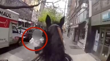Police officer on a horse is chasing a suspect on a sidewalk.