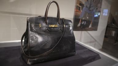 Jane Birkin's original large black leather bag sits in a glass case