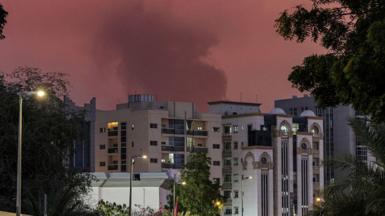 Plume of smoke rises behind high-rise buildings in the UAE emirate of plume of black smoke rises from the port of Fujairah (04/03/26)