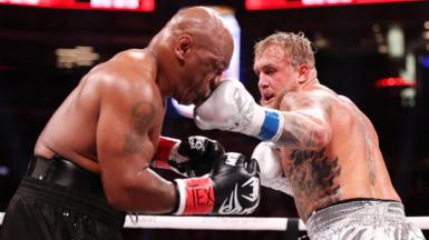 (L-R) Mike Tyson and Jake Paul fight during LIVE On Netflix: Jake Paul vs. Mike Tyson at AT&T Stadium 
