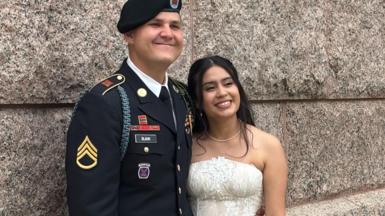 US Army Staff Sgt Matthew Blank wears his army uniform as he hugs his wife Annie Ramos in her white strapless wedding gown. 