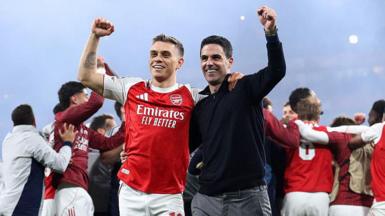 Leandro Trossard and Mikel Arteta celebrating on the Emirates Stadium pitch after beating Atletico Madrid.