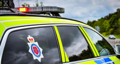 Library image of a Lancashire Constabulary police car, marked in fluorescent yellow and blue checks.