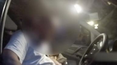 Man behind the wheel, his face is heavily blurred.