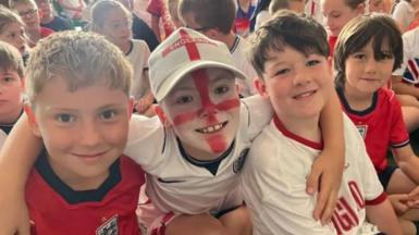 School kids smile watching the game on Monday morning.