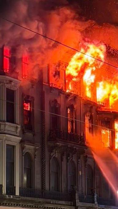 Large flames emitting from upper windows of Edinburgh building at night