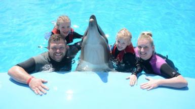 Laura and Paul Melling swimming with dolphins with their daughters in Egypt
