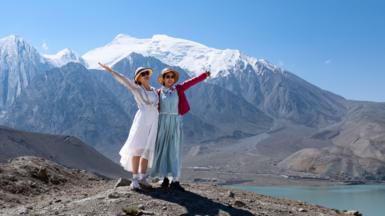 Two women posing for a picture at White Sand Lake in Xinjiang's Akto County