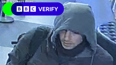 The "wanted individual" wearing a grey hoodie and jacket, with a mask wrapped around his neck and wearing a black backpack