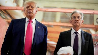 Donald Trump appears next to Jerome Powell, who is carrying a white hard hat, during a visit to the Federal Reserve building as it undergoes renovations.