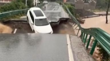 A white car falling into a hole in a collapsing bridge