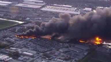 A long plume of smoke rises from Louisville, Kentucky over tens of buildings.