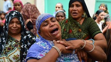 Relatives and neighbours of Akash Patni, a 14 years old tea vendor who died in Air India Boeing 787 Crash, mourn as they wait for the dead body at his residence, on June 15, 2025 in Ahmedabad, India. 