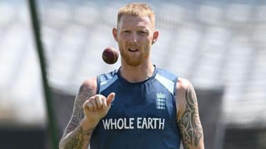 Ben Stokes, wearing a blue England vest, tosses a ball in the air