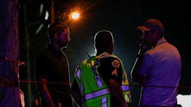 Law enforcement officers talk to each other after reports of shots fired outside Donald Trump's golf course