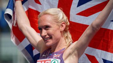 Calli Hauger-Thackery holds up a union jack as she celebrates her bronze medal for Great Britain in the women's half-marathon at the 2024 European Athletics Championships in Rome