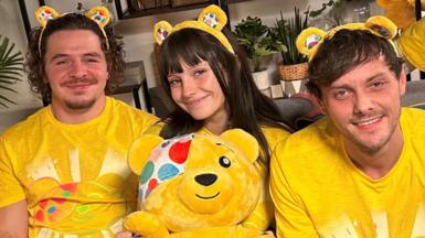 The former child stars of Outnumbered wearing yellow Children In Need T-shirts and Pudsey ears, with a Pudsey cuddly toy