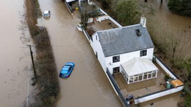 An aerial view of a flooded car and house