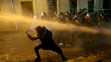  Police officers use water cannons to desperse demonstrators during clashes as part of a protest outside the Parliament building against the government's decision to delay European Union membership talks amid a post-election crisis, in Tbilisi on December 1, 2024.