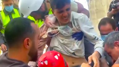 A young man is rescued from the rubble.