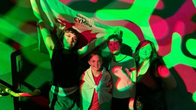Adwaith a Maddie gyda baneri Cymru