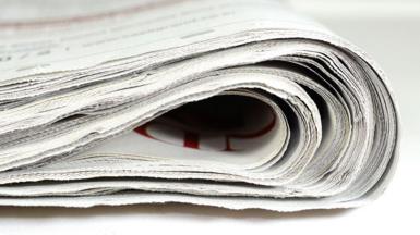 A stock image shows the edge of a folded newspaper.