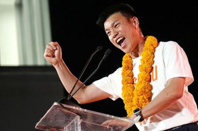 People's Party leader and prime ministerial candidate Natthaphong Ruengpanyawut, wearing a white T-shirt with an orange garland around his neck, addresses a campaign rally ahead of the general election in Bangkok on January 25, 2026