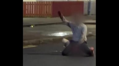 A image of a man with his hand up in the air. His face is blurred. 