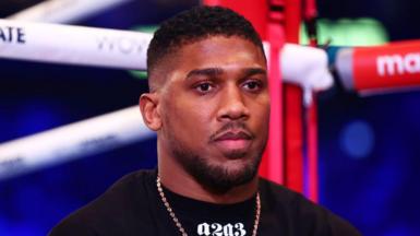 Anthony Joshua looks on from ringside during an interview