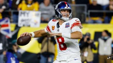 Daniel Jones prepares to throw an American Football