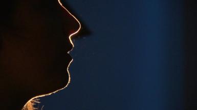 Profile silhouette of anonymous source mid-speech