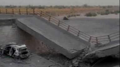 A damaged portion of the bridge in the aftermath of the overnight strike in Bandar Khamir, Hormozgan province. The image shows a portion of the bridge collapsed with rubble surrounding it, it is positioned diagonally with a damaged car