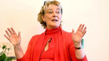 Jo Malone in 2019 wearing an orange dress, with cropped blonde hair and a watch.