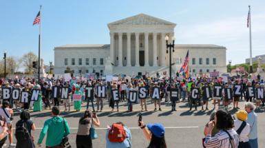 Demonstrators hold letters making up the slogan "Born in the USA = citizen!" outside the U.S. Supreme Court building  