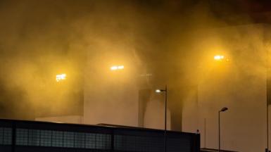 Smoke coming from the white building at night-time.