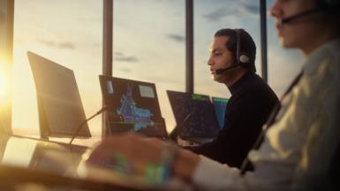 Stock image of a male air traffic controller with headset in airport tower. 