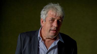 Rod Liddle looking up to his right, wearing a blue-striped shirt and navy jacket