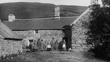 Teulu o flaen tŷ cerrig