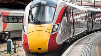 An Azuma train has been stopped at a platform. Other trains have stopped at the station.