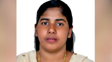 A picture of Nimisha Priya wearing gold jewellery, her hair tied back. She is wearing a beige-coloured Indian suit. 