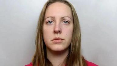Custody image of Lucy Letby, who has long blonde hair and is wearing a red top.