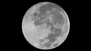 A close up picture of a full moon on a black night sky