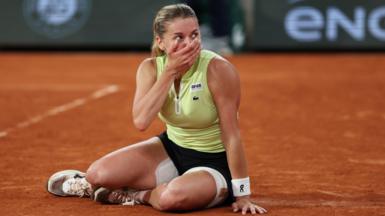 Maja Chwalinska sits on the ground and covers her face with her hand after reaching the French Open final