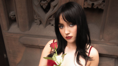 A woman with black hair in a red dress holding white and red roses