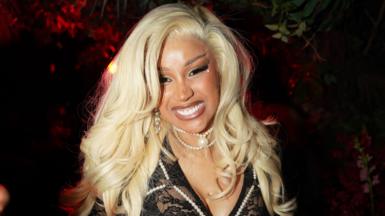 Cardi B smiling in a blonde wig