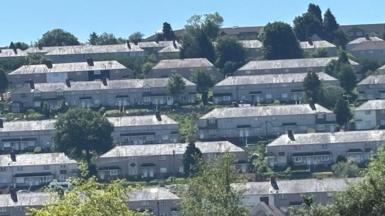 Rows of terraced housing in Townhill, with lots of green trees and a sunny blue sky overhead