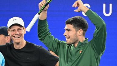 Jannik Sinner and Carlos Alcaraz watch on at the Australian Open