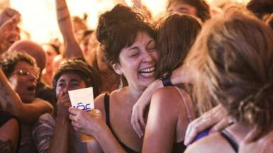 Two young women hug each other in a crowd as they react to election victory of the New Popular Front, a coalition of French left-wing parties in France.