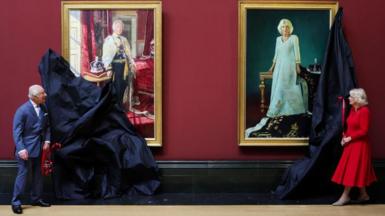 King Charles and Queen Camilla removing covers from portraits depicting them