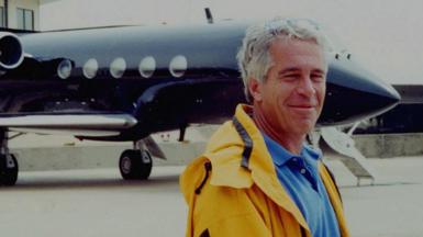 Jeffrey Epstein standing in front of his private plane